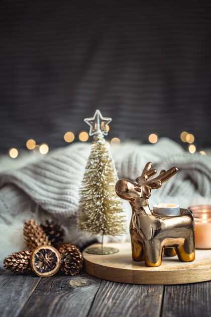 华丽圣诞喜庆的背景与玩具鹿 模糊的背景与金色的灯光和蜡烛聚会圣诞节手工制作