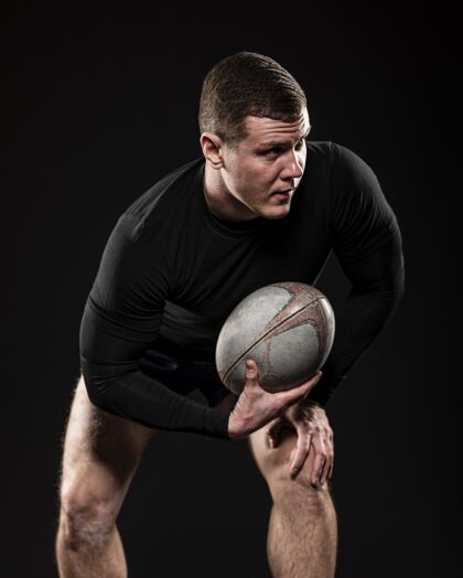 联盟男橄榄球运动员单手持球前视图完全活动垂直