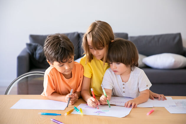 女儿高加索儿童在客厅用马克笔画画可爱的小男孩和金发女孩坐在一起 在纸上画画 在家里玩耍童年 创造力和周末的概念可爱沙发发展