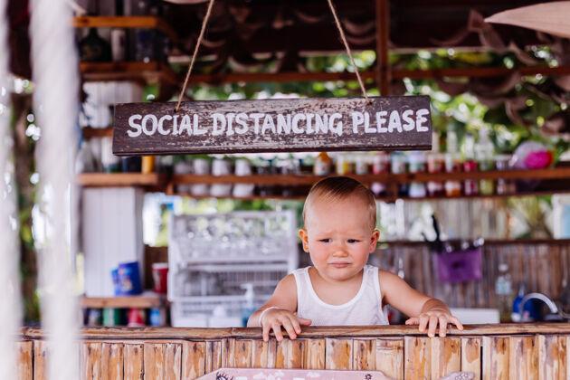 新的在泰国度假的小男婴 在酒吧有社交距离标志儿童标志男孩