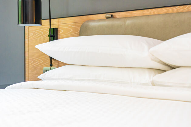 舒适床上的白色枕头和毯子装饰卧室内部装饰枕头纺织品