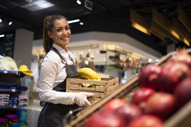 购物超市工作人员为水果部提供食物室内超市工人冷冻