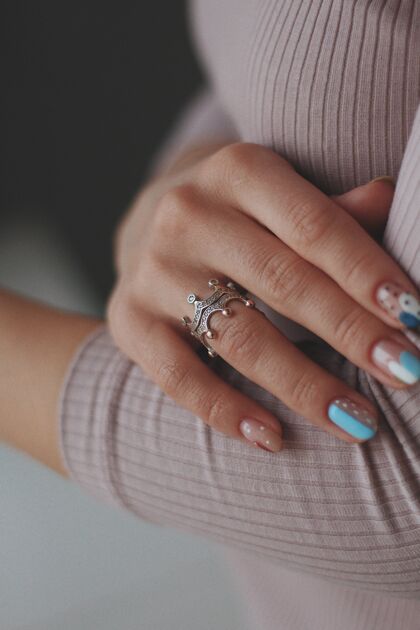 化妆品垂直特写一个女性漂亮的指甲戴着漂亮的银戒指奢侈品人类钻石