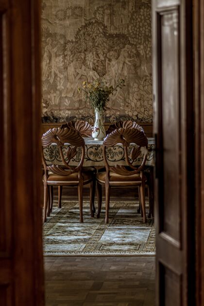 椅子从一扇敞开的门可以看到豪华餐厅的垂直图像 里面有华丽的椅子内部家具静物