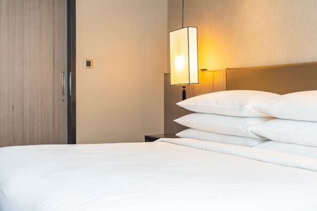 套房白色舒适的枕头和毯子装饰在卧室的床内公寓毯子枕头