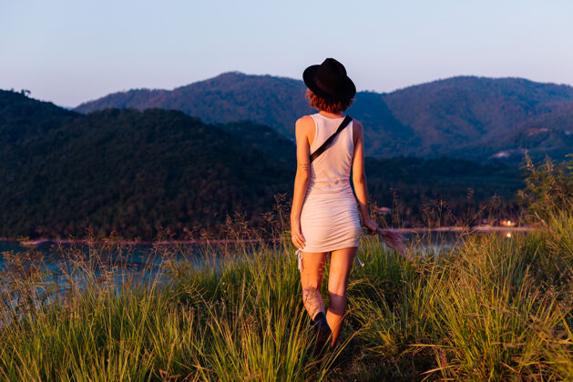 户外穿着夏装的年轻白种女人的浪漫肖像 在山上的公园里享受放松 美丽的热带海景 度假的女人 在泰国旅游日落时的快乐女人热带漂亮异国情调
