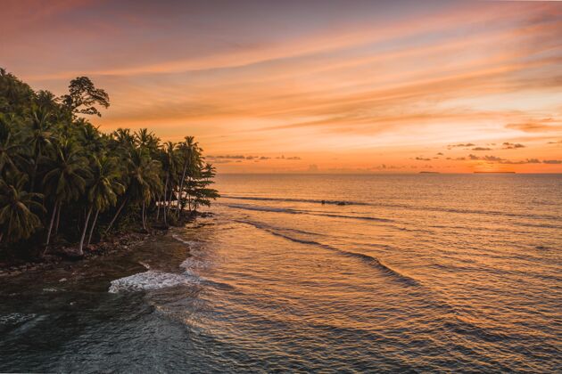 海洋印尼日落时分 静谧的海洋和岸边树木的迷人景色海景印度尼西亚棕榈