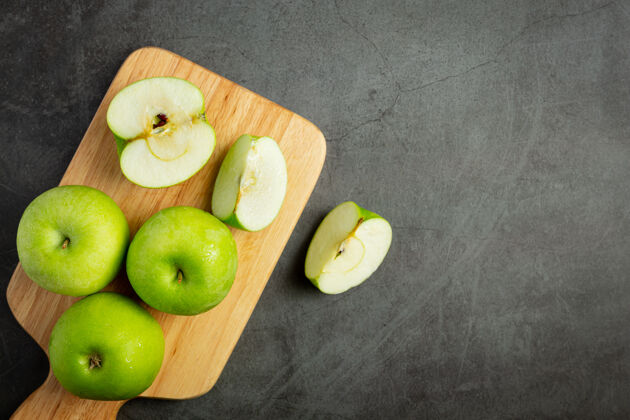 甜味新鲜的青苹果切成两半放在木砧板上护理丰度有机