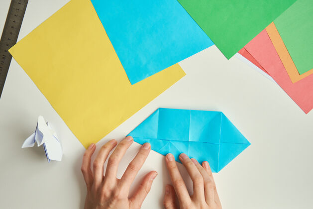 生产折纸课女人用彩纸做折纸复活节兔子diy概念制作文化过程