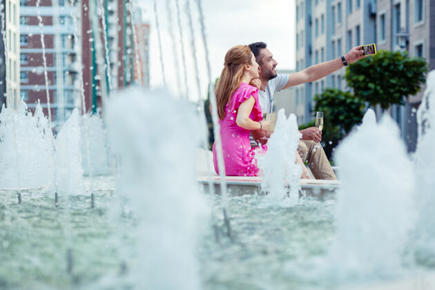 设备我们的记忆快乐的夫妇坐在喷泉边一起自拍一起关系周末
