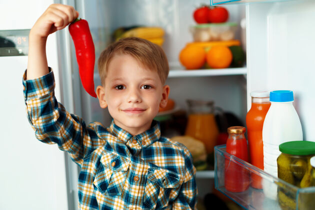 厨房小男孩站在打开的冰箱前挑选食物年轻人肖像