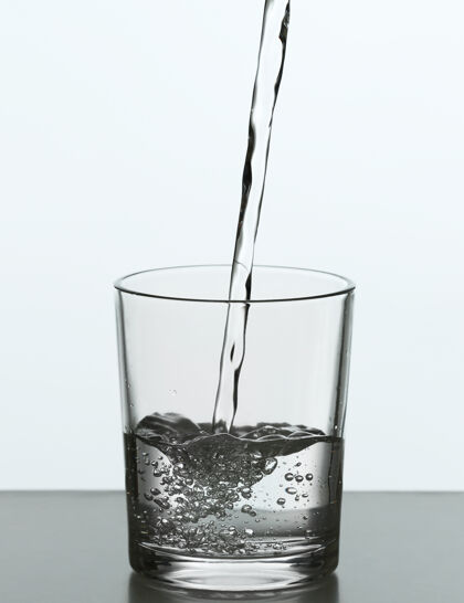 自然把瓶子里的水倒在白色的玻璃上卫生瀑布清晰