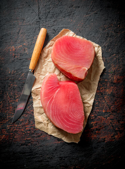 海把新鲜生金枪鱼牛排放在纸上 用刀放在乡下的桌子上鱼片美食俯视图