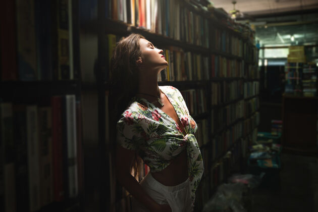 兴趣古董书店里年轻性感的女人阅读读者时尚