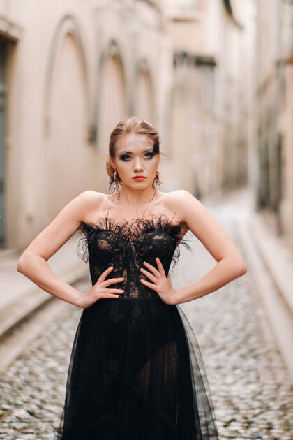 长一位身着黑色婚纱的时尚新娘在法国古城阿维尼翁摆出姿势穿着漂亮的黑色连衣裙的模特在普罗旺斯拍照石头城黑裙老法国