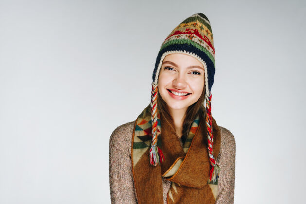 女性戴着暖和帽子的女人高兴地笑着手臂针织有趣