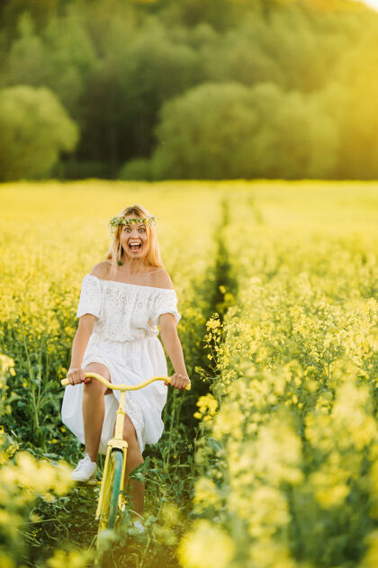 自行车一个女人在一片全是鲜黄色油菜籽的地里骑自行车情绪自行车心情