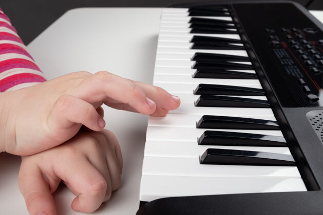 年轻学习弹钢琴 小女孩手上的合成器键迷笛音乐家教育