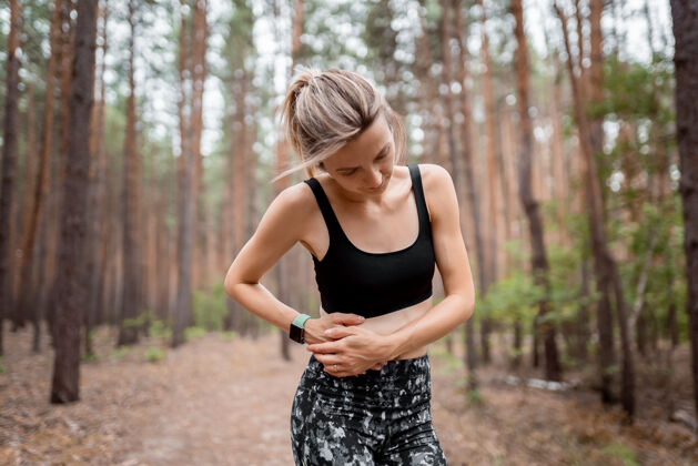 年轻边缝女跑步者边抽筋后运行慢跑运动后腹痛的慢跑妇女女运动员体育 健康和人的概念医学问题两者