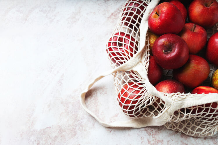 食品苹果在网袋里发芽可持续性和有意识的消费观念顶视图平躺自然袋水果