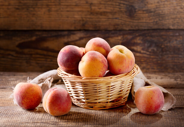 新鲜木桌上篮子里的新鲜桃子木材水果桃