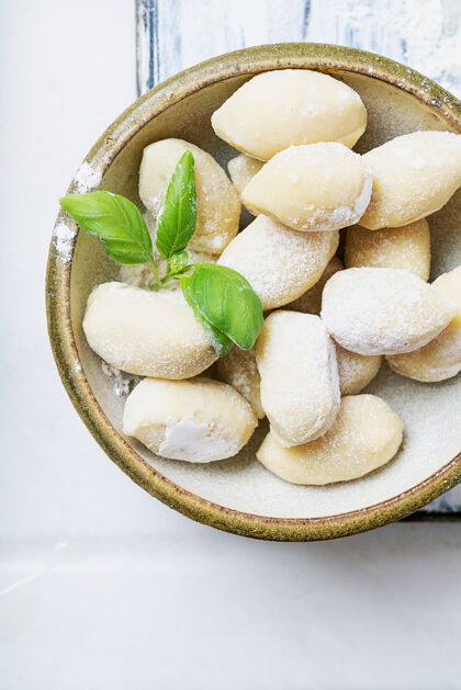 食物传统的意大利土豆面食 用罗勒叶 鸡蛋 面粉装饰生面概念顶视图平躺餐桌食谱制作
