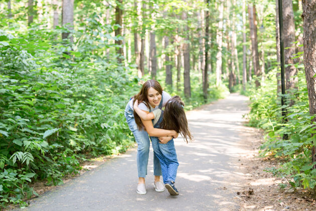 无忧无虑自然 母爱和孩子的概念-快乐的母亲和小女儿在绿色公园玩拥抱家庭休闲