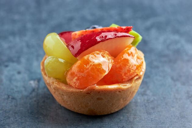 吃迷你优质新鲜水果甜点放在海绵蛋糕上草莓蓝莓猕猴桃