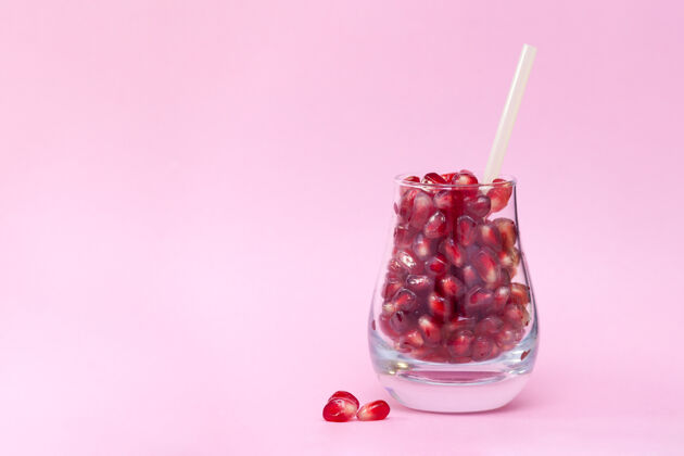 素食在粉红色的玻璃上种植种子背景健康 有机产品概念.copy空间美味最小石榴