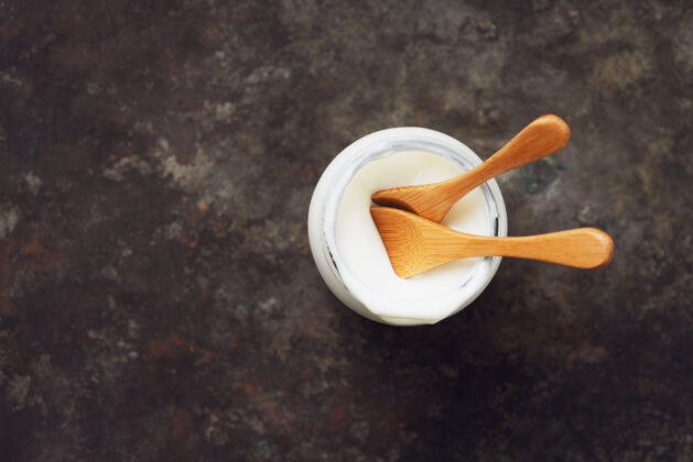 玻璃纯白色酸奶放在玻璃罐里 配椰子勺顶视图平铺可持续发展理念有机景观牛奶