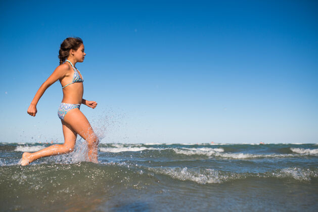 天空一个快乐的积极的小女孩在阳光明媚的夏日游泳的肖像年轻海岸快乐