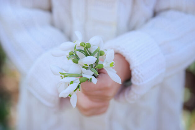 前一束雪球在一个小女孩手里初春的花朵复活节时间新鲜优雅女