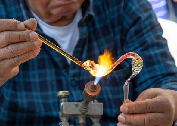 手工男吹玻璃工在煤气炉下做手工制品手指火雕像
