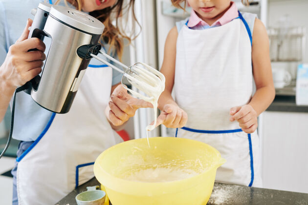 碗母亲和女儿品尝他们为蛋糕做的甜奶油的剪短图像蛋糕健活方式成人
