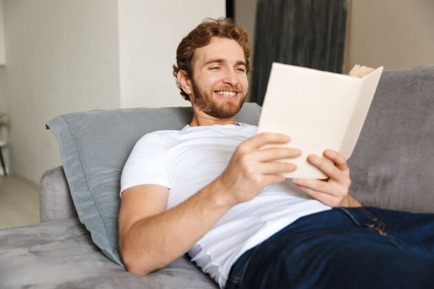 白种人一个留着胡子的帅哥坐在家里的沙发上看书教育知识家庭
