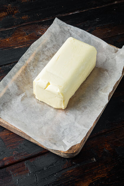 乳制品乡村农舍的灵感新鲜黄油 在旧的深色木桌上健康块黄油