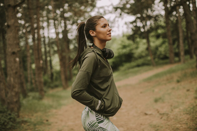 播放器在森林里慢跑后 听音乐休息的年轻漂亮的女跑步者森林20多岁巴西