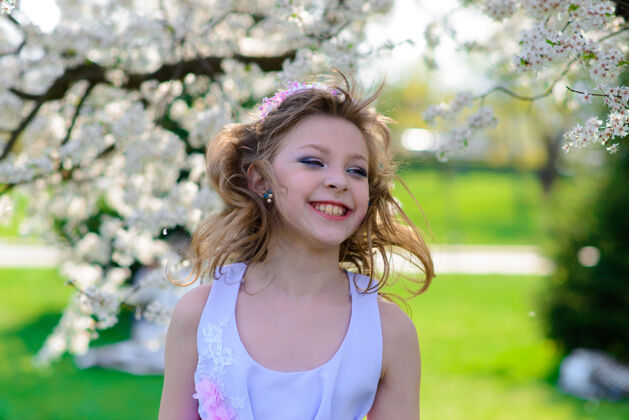 自然美丽的春天 美丽的小女孩在盛开的苹果园里金发春天树