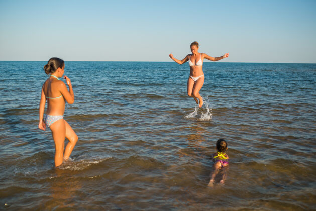 海洋妈妈和女儿在海里玩年轻海女孩