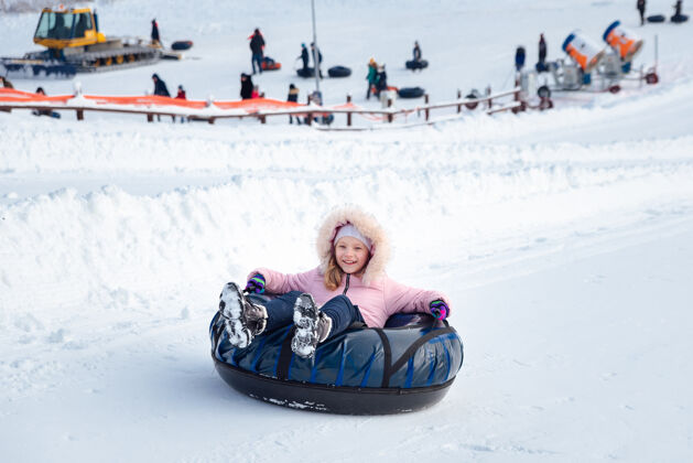 娱乐一个小女孩骑着管子滑下滑梯雪衣服基地