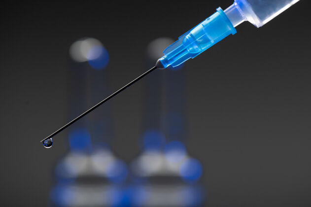 保持一个带有冠状病毒疫苗和针头的医用注射器的一部分疾病流感疫苗