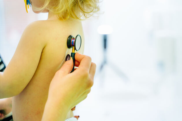 医学女孩和医生用听诊器听心跳的特写镜头疾病人听