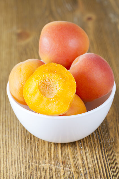 吃新鲜成熟多汁的漂亮杏子放在桌子上的碗里 特写镜头成熟花园餐桌