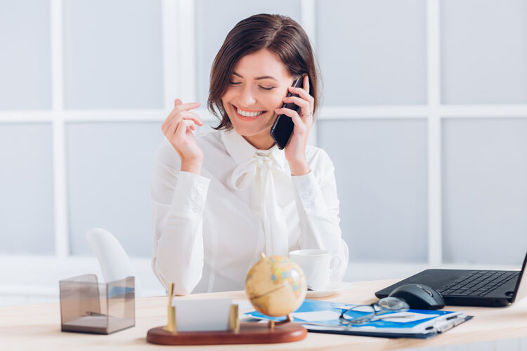 企业家漂亮的女商人在办公室打电话和办公桌边工作肖像现代