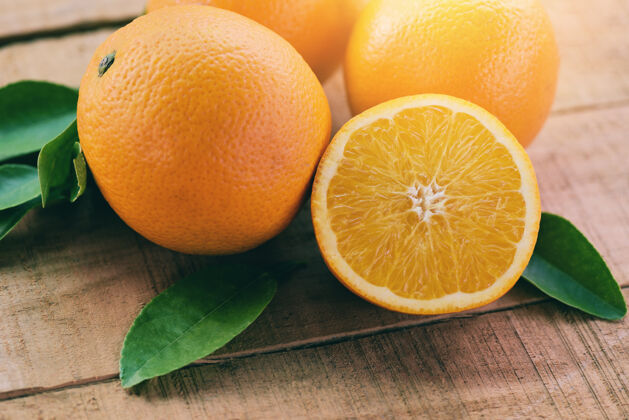健康木质和自然背景上有叶子的橙色水果 新鲜的橙色叶子是健康的水果有机甜酸橙