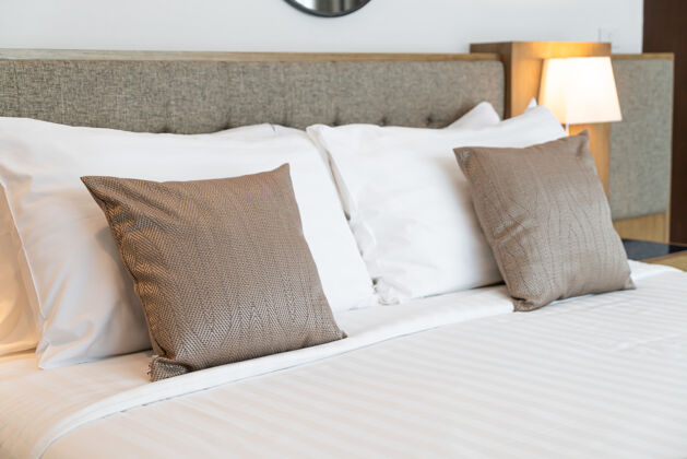 生活漂亮的床上枕头装饰房间内部豪华棕色公寓