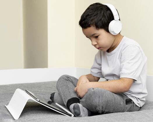 科技戴耳机的男孩用平板电脑年轻人平板电脑孩子