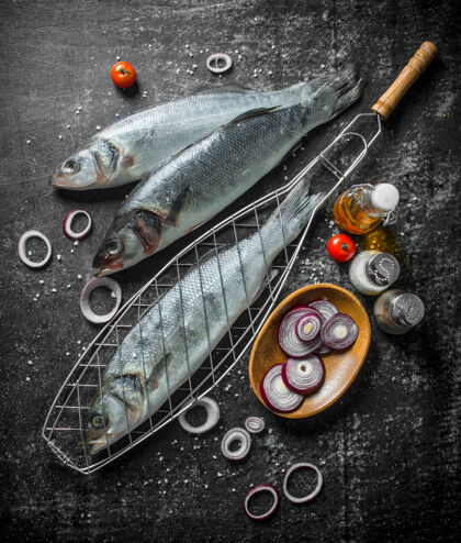 架子生鱼配香料 西红柿和洋葱圈放在乡村餐桌上整个营养膳食
