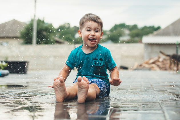 玩情绪激动的白人男孩正在后院的地上玩水 对着镜头微笑滴欢呼户外
