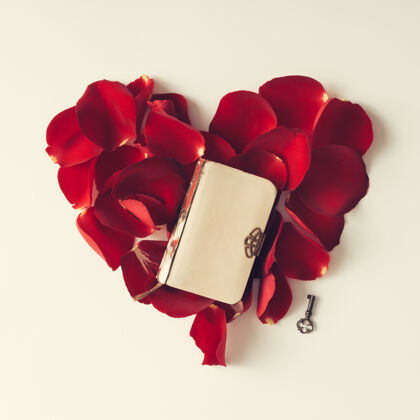 情人节红色玫瑰花瓣呈心形 书上有白色墙.平的躺下感觉形状新鲜